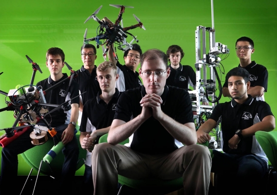 The UNSW mechatronics team and three of their rescue robots. Left to right: Dominik Daners, Chris Lu, Harry Dudley-Bestow, Stanley Lam, Mark Whitty (centre), William Andrew, Daniel Castillo, Chung Lam. Photo: Grant Turner/Mediakoo
