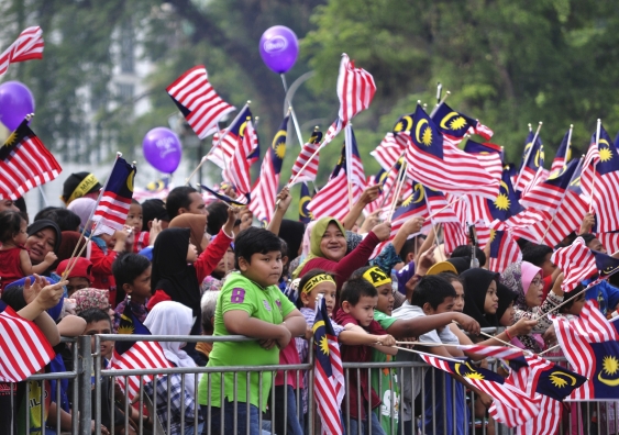 Crowd waving a Malaysian flags during 57th celebration of Malaysia Independence Day in Kuala Lumpur, Malaysia. Image: iStock