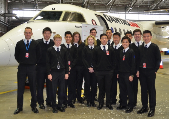 Katie Seymour, Hayley Umbers and fellow UNSW Aviation students with a QantasLink Dash-8 Q400 aircraft