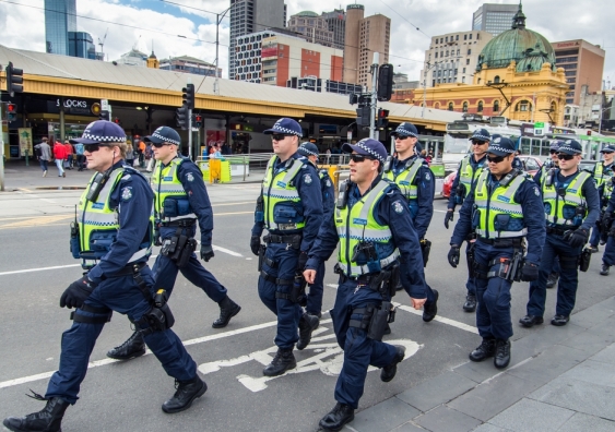 Victoria Police officers marching in formation along Swanston Street, between Flinders Street Station and Federation Square. Image from Shutterstock