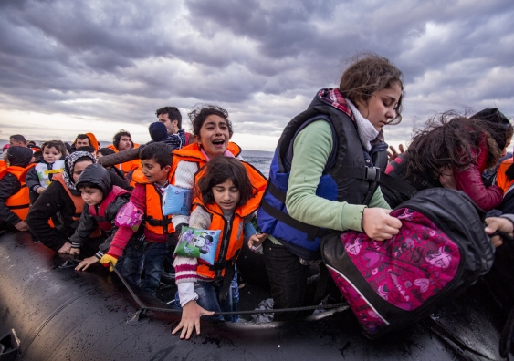 Syrian refugees arrive from Turkey on boat through sea with cold water near Molyvos, Lesbos. Photo Credit: Nicolas Economou/Shutterstock.
