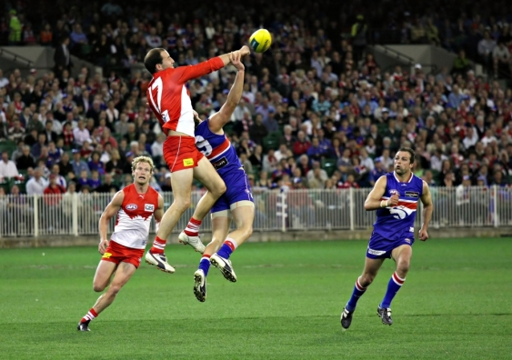 Former Sydney Swans star Tadhg Kennelly (in red, jumping) is one of four new inductees into the UNSW Sports Hall of Fame. Image from Shutterstock