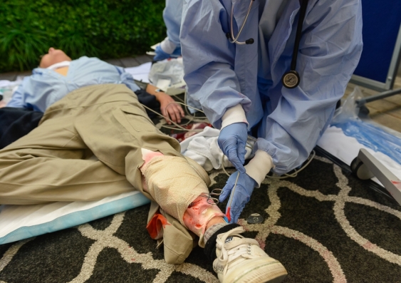 A medical student works to stabilise the patient (professional actor) during the SimWars competition. Photo: Dan Gray