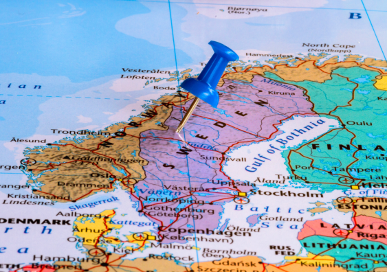Map of Sweden and surrounding countries with blue pushpin stuck to Sweden.