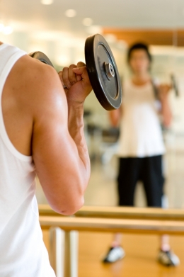 Man lifting weights in front of mirror