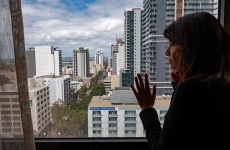Image of a woman peering out of a hotel window