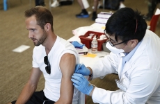 A man about to get a vaccine from a medical worker