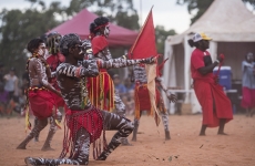 Indigenous Australians in tribal gear perform in a ceremony