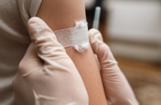 A child receives a bandage on the arm after being immunised