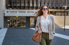 A woman with sunglasses on smiles as she leaves for the day