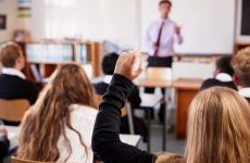 a student raising their hand in a classroom