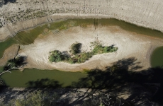 an aerial view of a river that is affected with algae and evaporating away