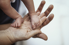 baby feet standing up on parents hands