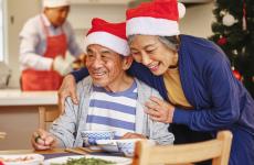Woman hugging elderly man at the Christmas dinner table