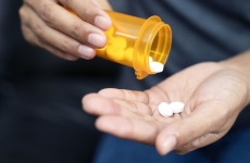 Patient dispensing tablets of medication into hand