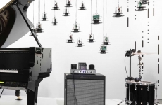 museum sound installation featuring piano, amplifier, drum with cymbal and lights