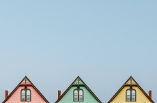 Three colourful houses with blue sky