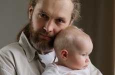 Close-up portrait of a man holding a baby