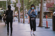 woman in face mask walking down the street during a coronavirus lockdown