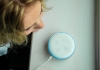 A young girl speaks over an Alexa virtual assistant device