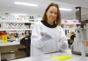 Scientist Emma Harding smiles as she works in a laboratory with a pipette