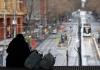 A homeless person sits on a platform overlooking a Melbourne street