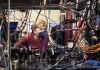 Angela Merkel peers out from a mass of wires and machinery