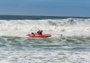 Life savers in a surf rescue boat attempt a rescue in rough surf