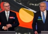 Anthony Albanese and Scott Morrison in front of the Australian Aboriginal Flag