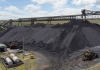 Bulldozers shown next to a huge pile of coal at a mining site