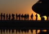 silhouette of soldiers boarding a plane
