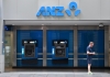 a man walks past anz automatic tellers in a wall