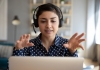 a woman talking on her computer gestures energetically with her hands