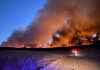 bushfires burning on the horizon at dusk on a farm