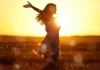 woman in sunshine with arms outstretched