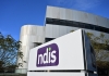 The NDIS logo in front of a building
