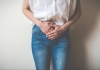 Woman with hands in front of her pelvis