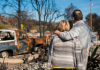 Couple stand at the ruins of their home after bushfire