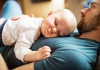 father with a baby at home sleeping