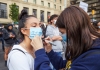 Female protestor writing 'I cant breathe' on fellow protestor's face mask