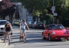 people on bicycles and a red car