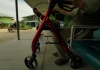 A person sitting while holding a walking frame