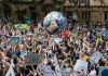 Climate change protest marchers toss around a large inflatable globe