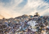 Truck drives over mountain of waste in landfill