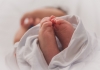 Close-up of newborn baby's feet poking out of blanket