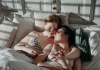 Two women in bed with arms around each other