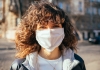 Portrait of a young woman wearing a white protective face mask