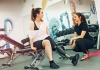 Woman in gym with prosthetic leg and personal trainer