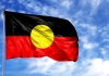 The Australian indigenous flag set against a cloudy blue sky