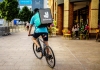 A Deliveroo delivery person riding a bike.